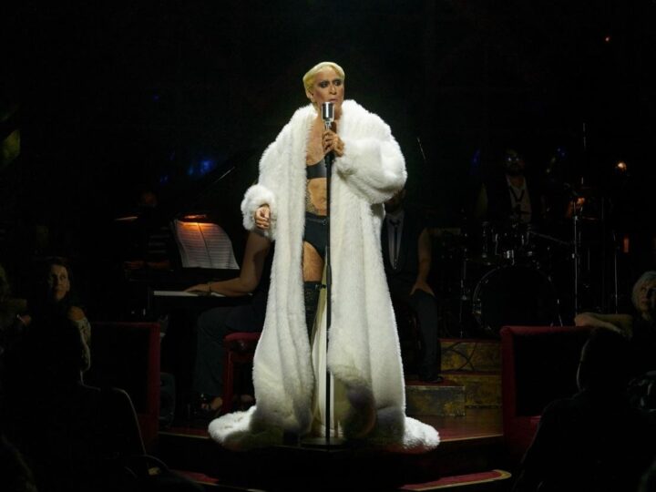 Mario Vaquerizo con abrigo blanco ante el micrófono en el Kit Kat Klub de Cabaret